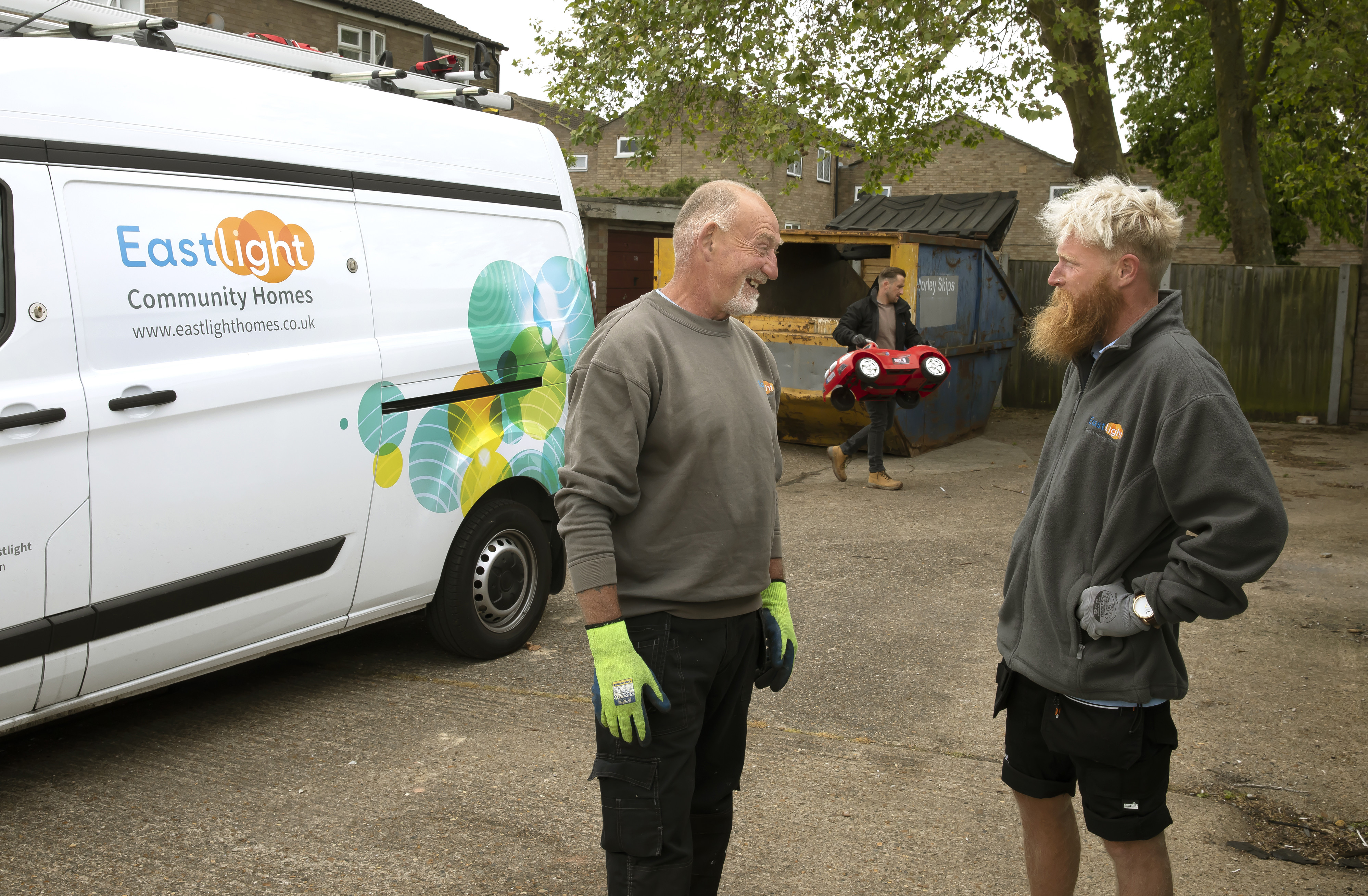 Two Eastlight estate rangers are stood talking next to an Eastlight van.