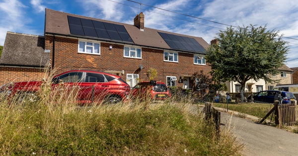 Two houses with solar panels on them.