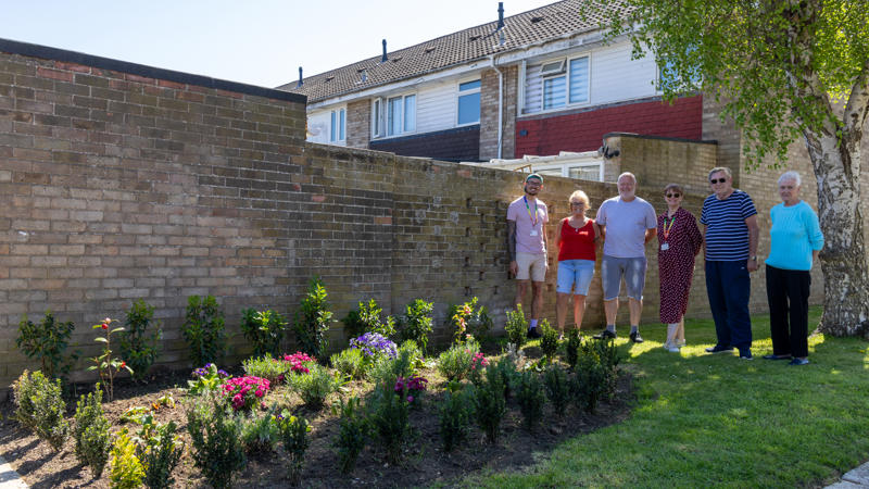 ERG Witham members are stood next to a newly installed flower bed.