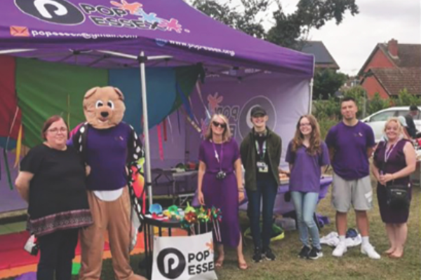 A group of people stood around a Pop Essex gazebo.