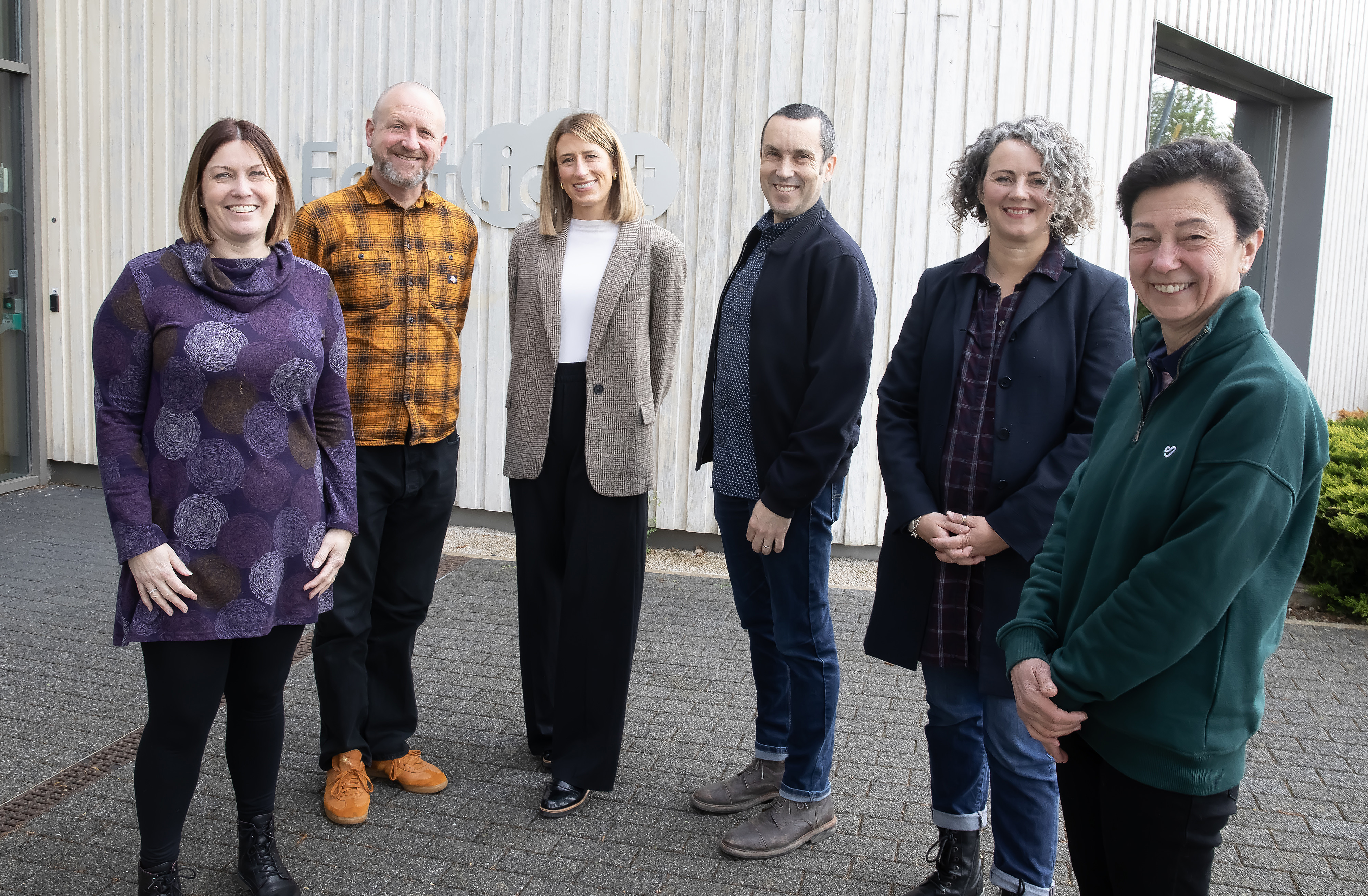 Eastlight Executives standing in front of the Eastlight head office in Braintree, all smiling at the camera