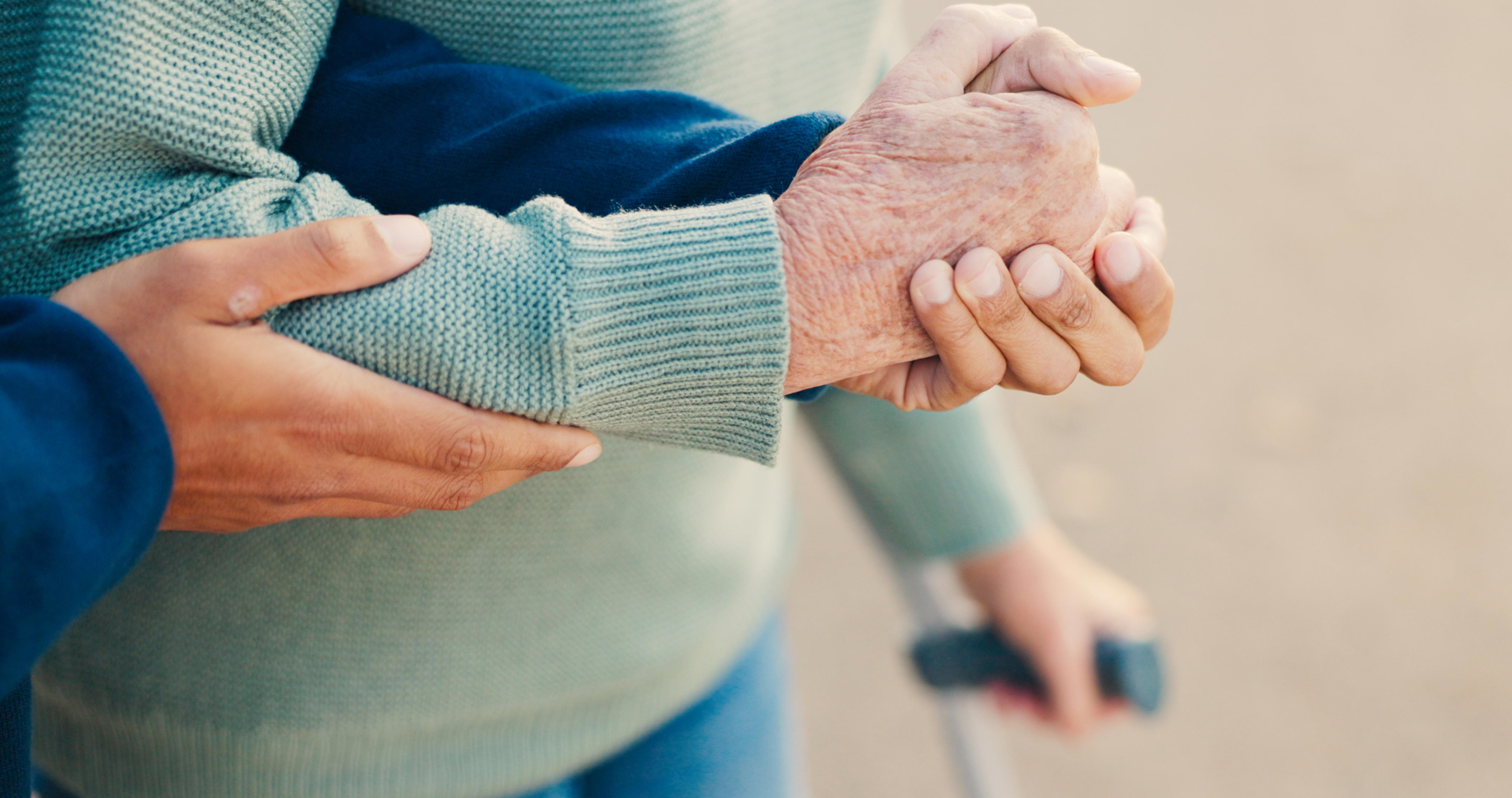 An older person is being helped along by a younger person